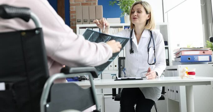 Doctor conducts medical consultation of patient in wheelchair