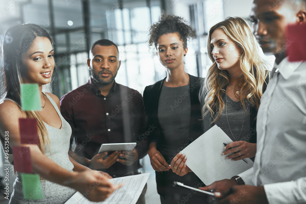 Sticker Chasing the next big idea in business. Shot of a group of young businesspeople brainstorming in a modern office.