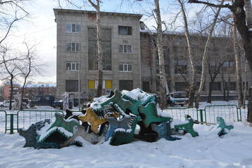 A bunch of old Soviet benches littered with snow