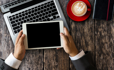 a woman using blank screen tablet with stylus on dark modern office desk