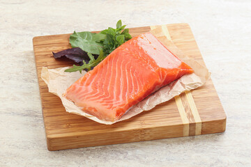 Raw salmon fillet over board