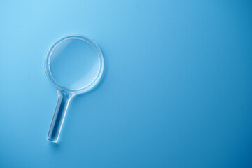 small magnifying glass against blue background