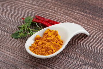 Yellow vibrant curcuma powder in the bowl
