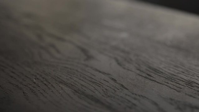 Slow motion handheld shot of black oak wood surface