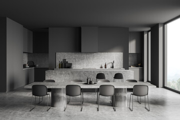 Dark kitchen interior with chairs and dining table, appliances and window