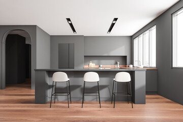 Obraz na płótnie Canvas Grey kitchen interior with island and bar chairs, kitchenware and panoramic window