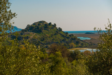 Fototapeta na wymiar KAUNOS, DALYAN, TURKEY: Landscape with a view of the lake and the Acropolis Hill in the ancient city of Kaunos.