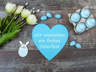  Osterkarte: Herz mit dem Schriftzug wir wünschen ein frohes Osterfest. Mit Ostereiern und Blumen.
