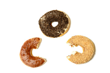 Drei Donuts mit hellen und dunklen Streuseln vor weißem Hintergrund