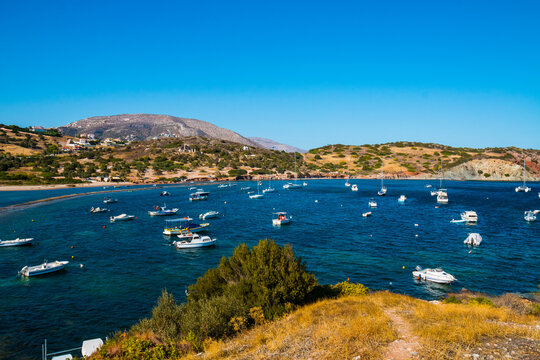 Boats and sailing yachts on anchor in the Anavyssos bay, Greece with very deep blue water and blue sky