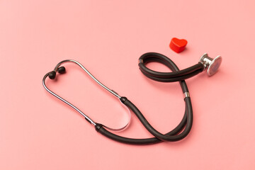 Fototapeta premium World health day concept. Stethoscope and red heart on pink background. Global health care