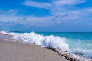 Incoming wave close-up. A wave with white splashes breaks on the beach. Florida, Atlantic Ocean
