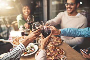 Thank you all for coming. Shot of a group of cheerful young friends having a celebratory toast with wine at dinner inside of a restaurant.