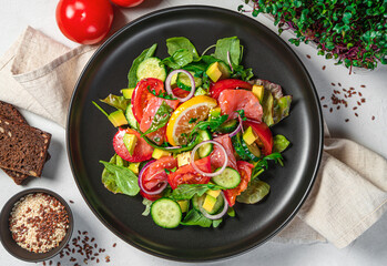 Vegetable salad with salmon, avocado, flax and sesame seeds with micro greenery. Top view, close-up. Healthy diet food.