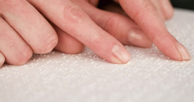 Blind man reading a text of Braille. Braille is a tactile writing system used by people with visual impairments.