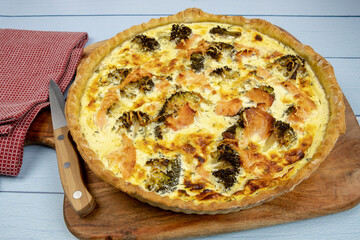 top view of a whole broccoli salmon pie on a wooden board