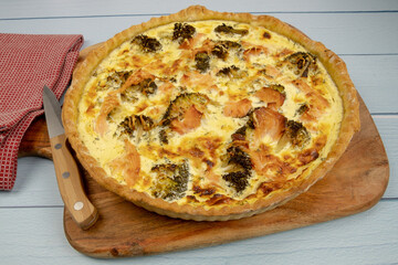 close up of a whole broccoli salmon pie on a wooden board