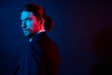 handsome man in a jacket posing self confidence dark background