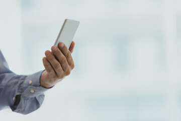 White smartphone held by a male hand, on a white background.