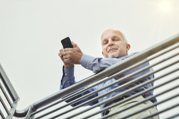 Nice man with a smartphone in a position of power in a corporate