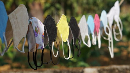 Colorful face masks put on a rope for drying after wash