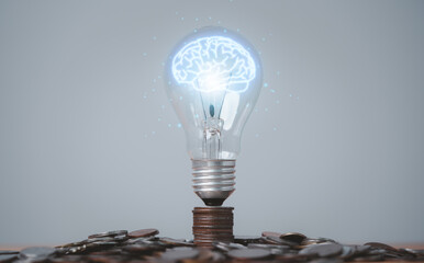 Glowing virtual brain inside lightbulb on coin stacking for creative thinking idea and innovation...