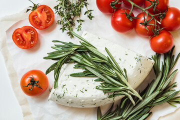 Brie or Camembert cheese with rosemary and tomatoes on white background. Top view - Powered by Adobe