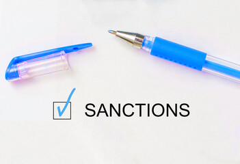check mark on the word sanctions and crossed lines and pen. Closeup, concept