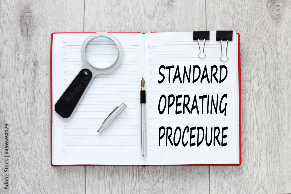 Poster sop - standard operating procedure, text on an open red notebook on a light background