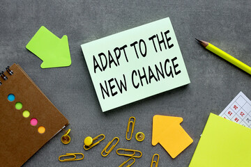 ADAPT TO THE NEW CHANGE. text on green sticky note on gray background