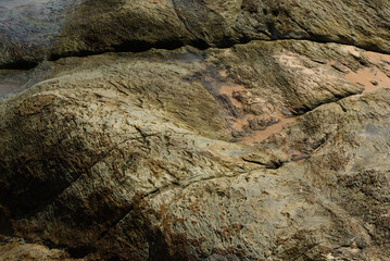 Closeup of massive rock with traces of sand
