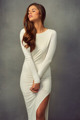 The more you stare, the more beautiful she gets. Studio shot of an attractive young woman posing against a grey background.