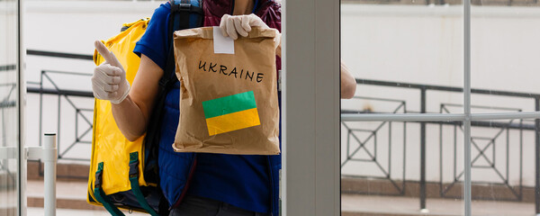 A man holds a box of aid for Ukrainian refugees and poor citizens who find themselves in a war...