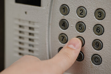 close up of a person holding a button, close-up of a hand pressing the intercom