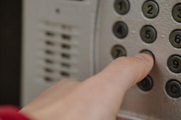 close-up of a hand pressing the intercom
