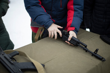 Children learn to shoot in Russia. Assembly of automatic weapons. Lesson in military training. Details of war training.