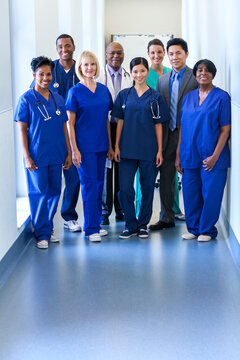 Portrait smiling multi ethnic medical team in uniform in modern hospital