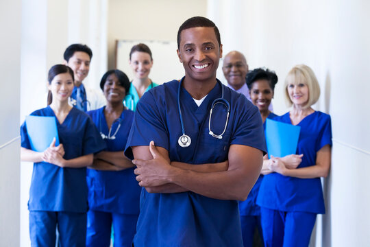 Smiling portrait male African American nurse with multi ethnic hospital team