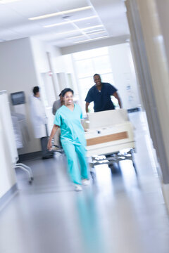 African American nursing staff in scrubs with hospital bed in healthcare centre
