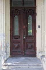 Fototapeta na wymiar One old brown door made of wood and glass.