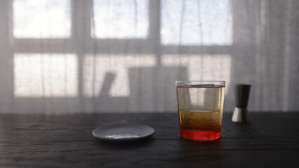tonic water with orange syrup in tumbler glass on wood table