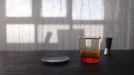 tonic water with orange syrup in tumbler glass on wood table