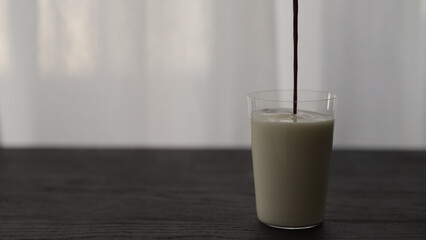 add berry juice in yogurt in tumbler glass with copy space