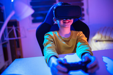 Fototapeta na wymiar Little boy playing video game using vr glasses in the dark room