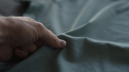 man hand touching blue cotton fabric