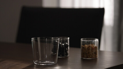 making granola with yogurt in tumbler glass on wood table