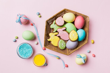 Fototapeta na wymiar Colorful easter cookies in basket with Multi colors Easter eggs on colored background . Pastel color Easter eggs. holiday concept with copy space