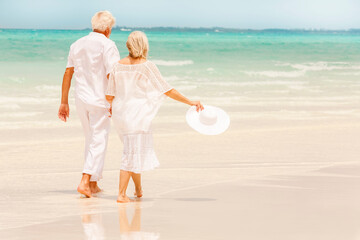 Attractive senior Caucasian couple in white living an island lifestyle on beach