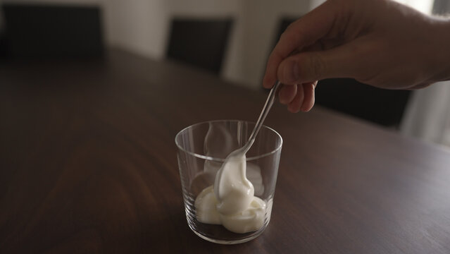 add yogut in tumbler glass on wood table
