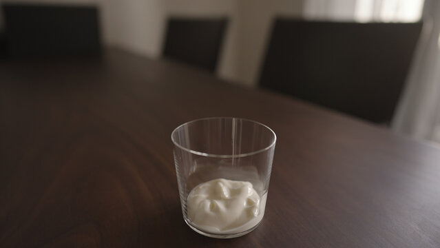 add yogut in tumbler glass on wood table